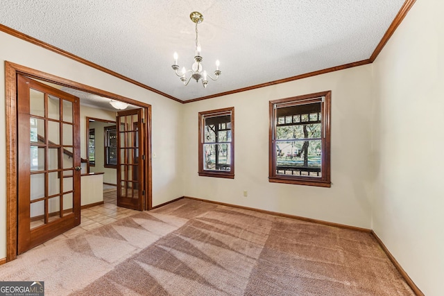 carpeted empty room with crown molding, a textured ceiling, a notable chandelier, and french doors