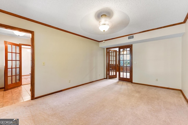 unfurnished room featuring ceiling fan, light carpet, a textured ceiling, french doors, and ornamental molding