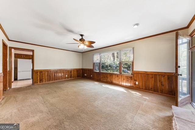 carpeted spare room with crown molding and ceiling fan