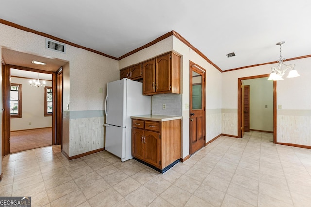 kitchen with an inviting chandelier, hanging light fixtures, light tile flooring, tasteful backsplash, and white refrigerator