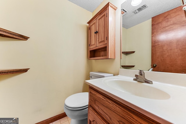 bathroom with toilet, tile flooring, a textured ceiling, and vanity