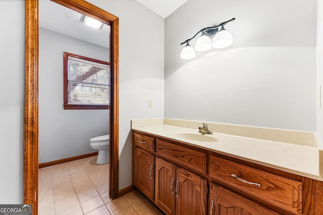 bathroom with vanity, a textured ceiling, tile floors, and toilet