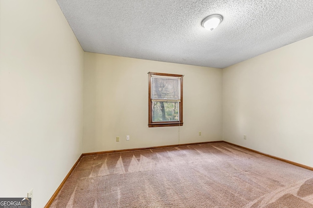 unfurnished room with light colored carpet and a textured ceiling