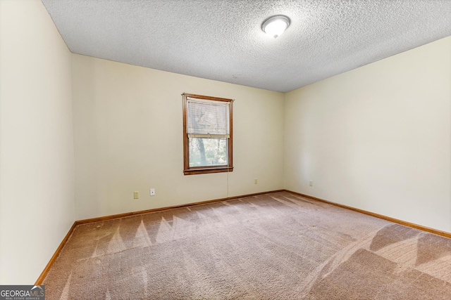 unfurnished room featuring a textured ceiling and light colored carpet