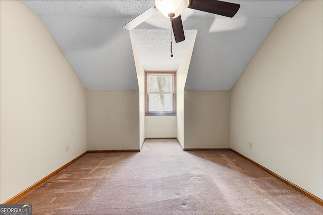 bonus room with ceiling fan, a textured ceiling, lofted ceiling, and light carpet