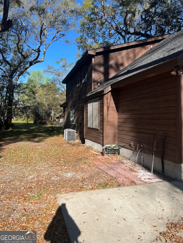 view of property exterior with central AC unit and a patio area