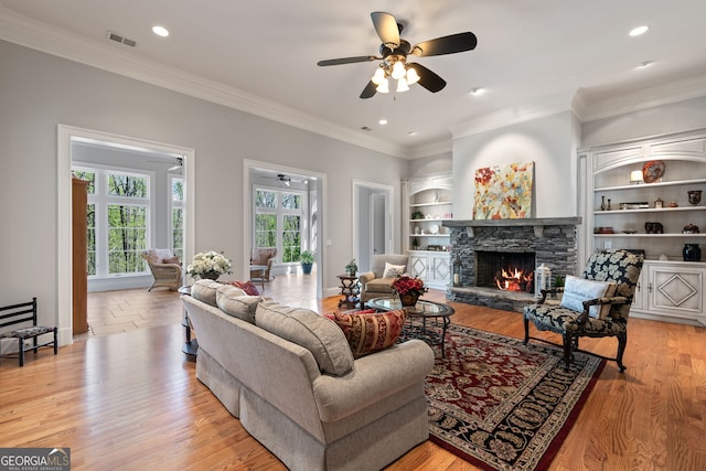 113 Hawks Ct, Ball Ground, GA 30107 - living room with ceiling fan, a stone fireplace, crown molding, recessed lighting, and built in shelves