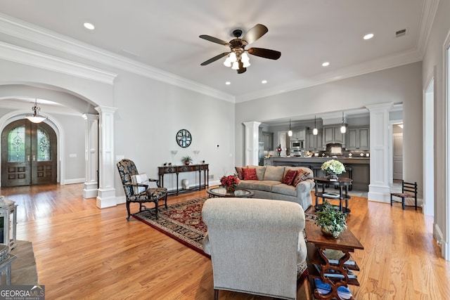 living room with ceiling fan, ornamental molding, and light hardwood / wood-style floors