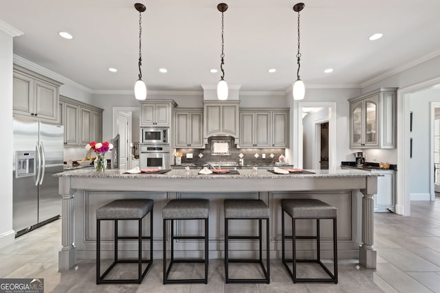 kitchen featuring stainless steel appliances, a spacious island, hanging light fixtures, tasteful backsplash, and a breakfast bar