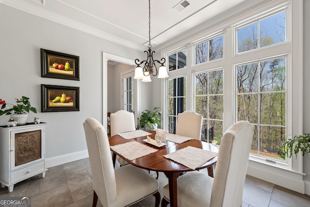 tiled dining space with an inviting chandelier and ornamental molding