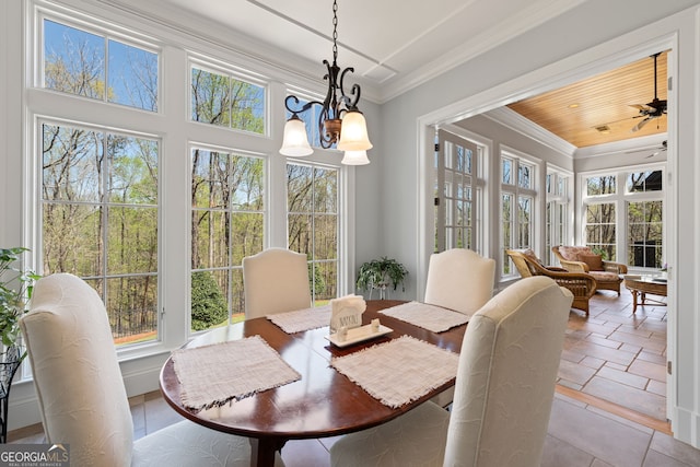 dining space featuring crown molding, plenty of natural light, and ceiling fan with notable chandelier