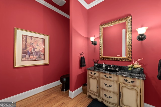 bathroom featuring ornamental molding, wood-type flooring, and vanity