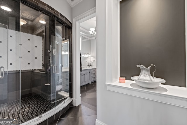 bathroom with tile floors, a shower with door, ornamental molding, and vanity