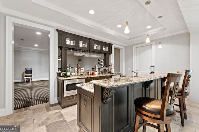 bar featuring decorative light fixtures, dark brown cabinetry, light stone countertops, and a tray ceiling