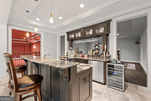 bar featuring wine cooler, dark brown cabinets, a tray ceiling, light stone countertops, and pendant lighting