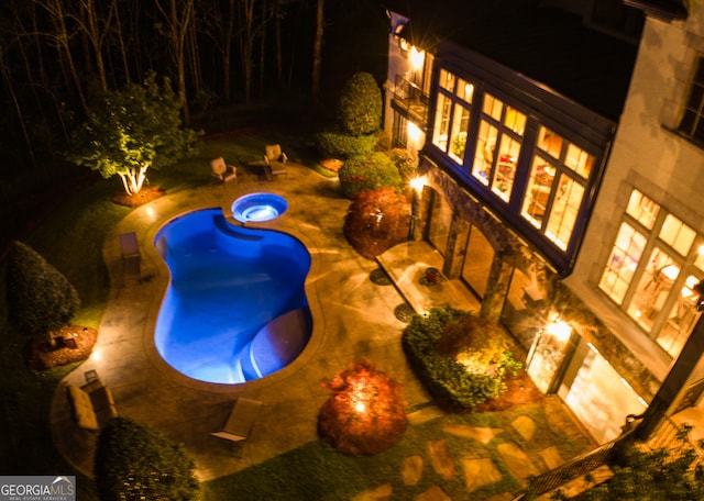 view of pool at twilight