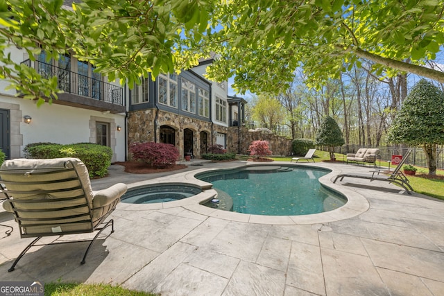 view of swimming pool featuring an in ground hot tub and a patio