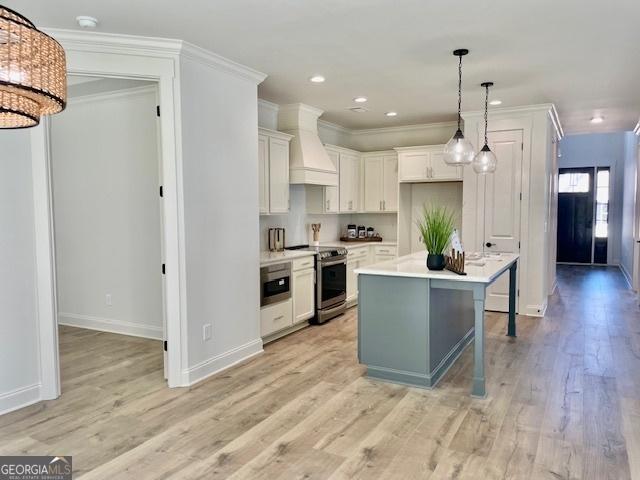 kitchen featuring a center island, stainless steel appliances, a breakfast bar, white cabinets, and custom range hood