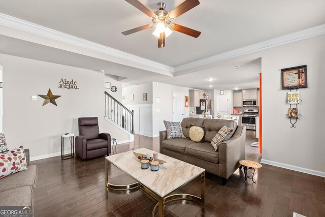 living room featuring dark hardwood / wood-style flooring, ceiling fan, and ornamental molding