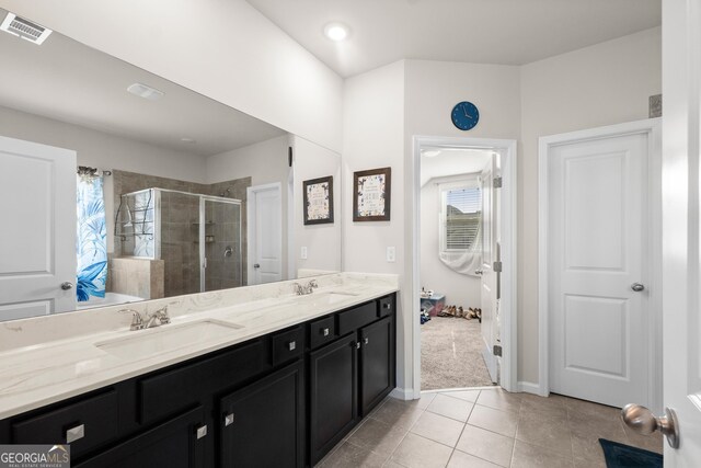 bathroom featuring oversized vanity, tile floors, dual sinks, and walk in shower