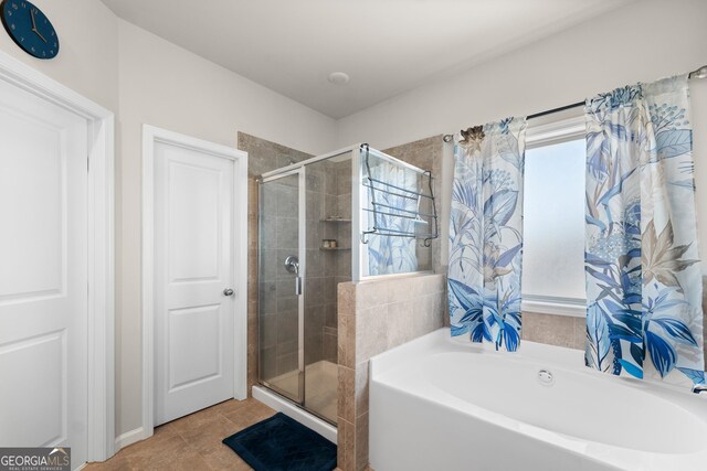 bathroom featuring plenty of natural light, independent shower and bath, and tile flooring