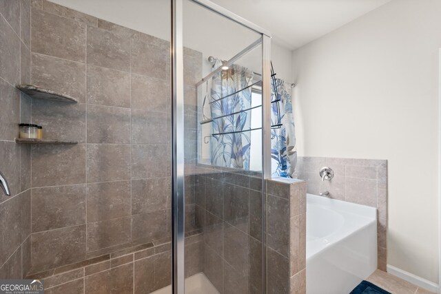 bathroom featuring plus walk in shower and tile flooring