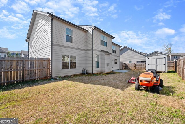 back of property with a yard and a shed