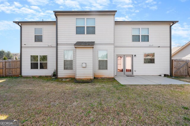 back of house featuring a patio and a lawn