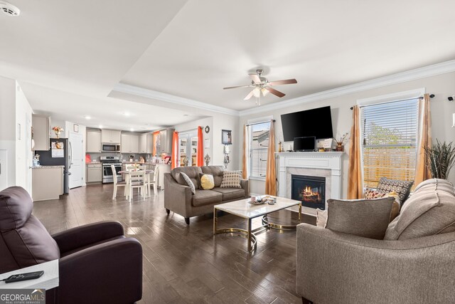 living room featuring crown molding, ceiling fan, and dark hardwood / wood-style flooring