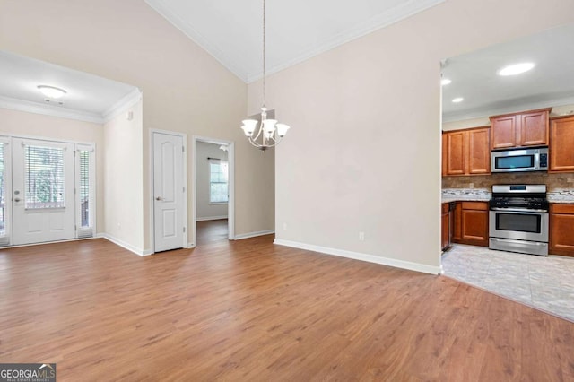 kitchen featuring a notable chandelier, appliances with stainless steel finishes, light hardwood / wood-style flooring, tasteful backsplash, and pendant lighting