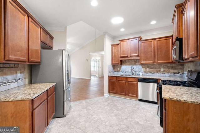 kitchen featuring appliances with stainless steel finishes, tasteful backsplash, pendant lighting, ornamental molding, and sink