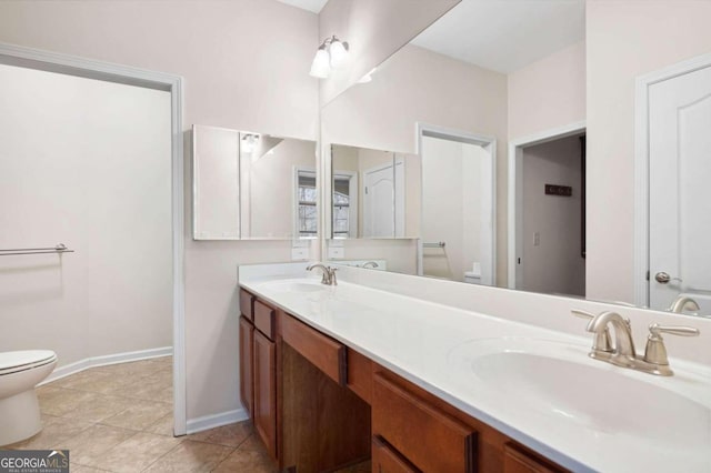 bathroom featuring double vanity, toilet, and tile floors