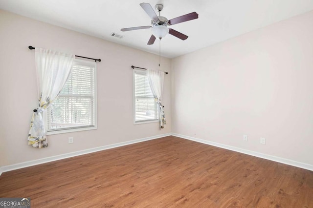 empty room with ceiling fan and dark wood-type flooring