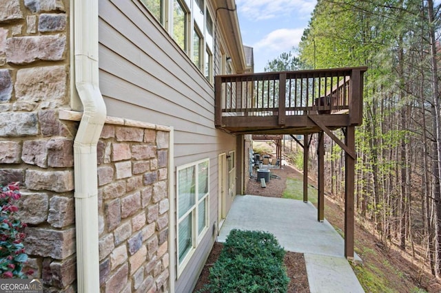 view of side of home with a wooden deck and central AC unit