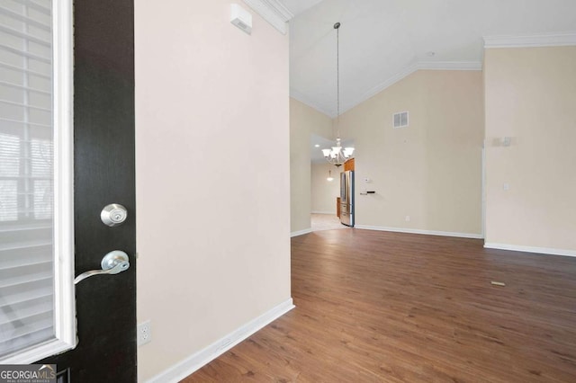 interior space with dark hardwood / wood-style flooring, crown molding, an inviting chandelier, and vaulted ceiling