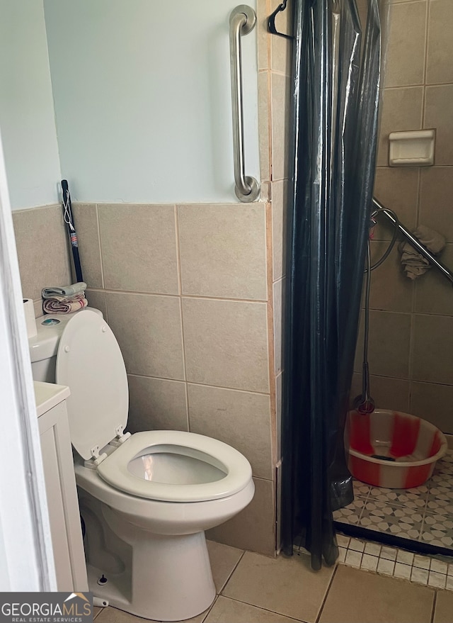 bathroom featuring tile flooring, toilet, and tile walls