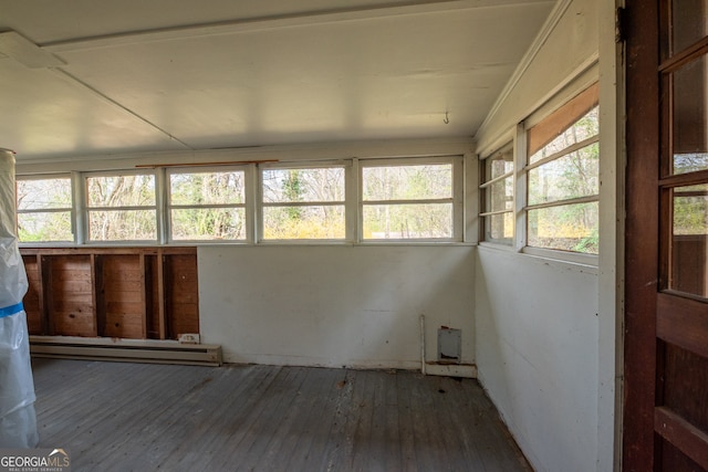 unfurnished sunroom featuring a baseboard radiator and a healthy amount of sunlight