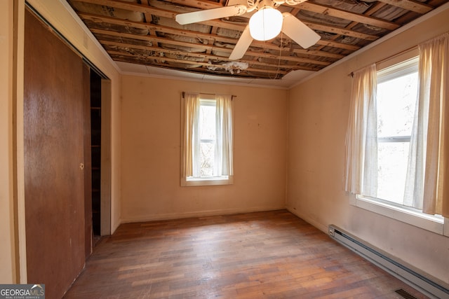 unfurnished bedroom with a closet, ceiling fan, wood-type flooring, and a baseboard radiator