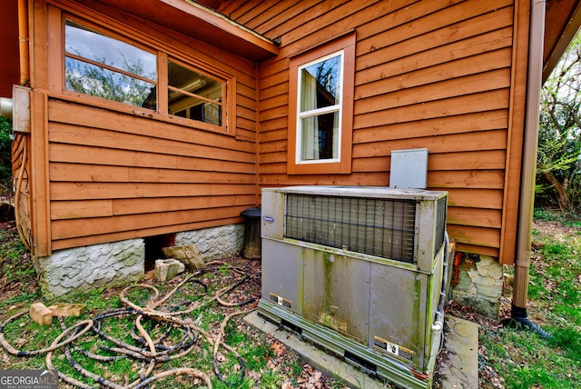 exterior details featuring log walls and central AC unit