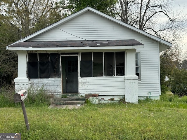 bungalow-style home with a front lawn