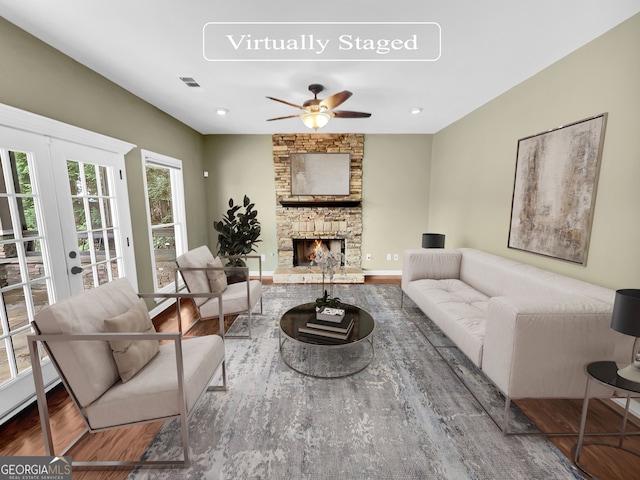 living room with ceiling fan, dark wood-type flooring, a fireplace, and french doors