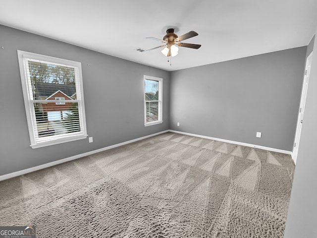 carpeted spare room featuring ceiling fan