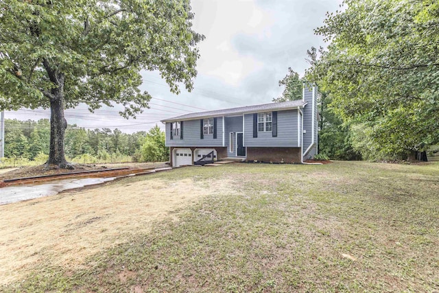 raised ranch with driveway, a front lawn, an attached garage, and a chimney