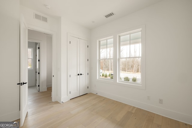 unfurnished bedroom featuring a closet and light hardwood / wood-style flooring