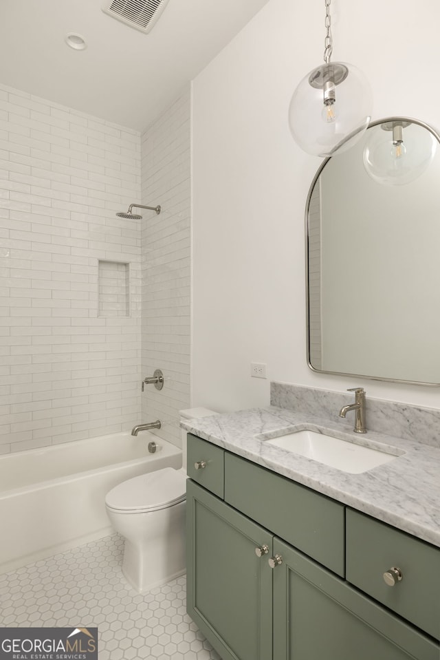 full bathroom featuring tiled shower / bath, vanity, tile patterned floors, and toilet