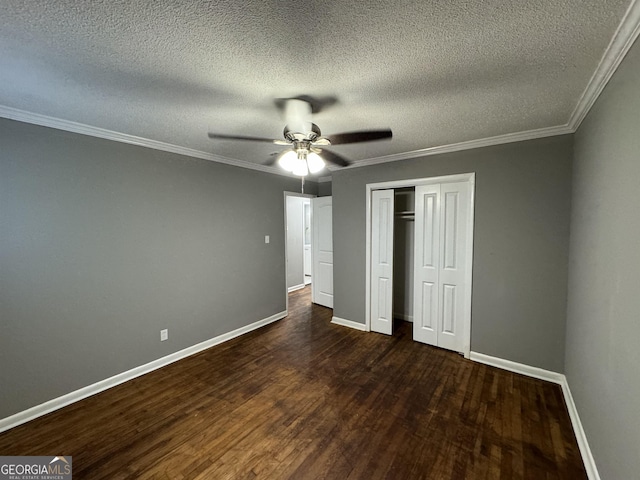 unfurnished bedroom with ceiling fan, a closet, crown molding, and dark hardwood / wood-style floors