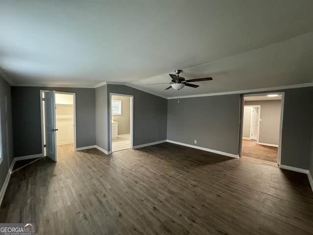 spare room featuring ceiling fan, dark wood-type flooring, vaulted ceiling, and ornamental molding