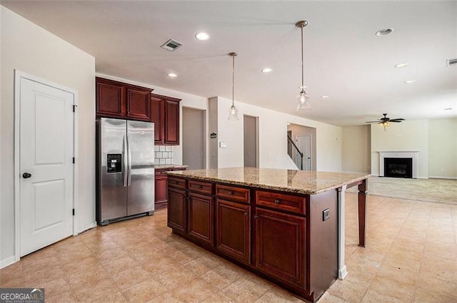 kitchen featuring hanging light fixtures, tasteful backsplash, a kitchen island, light tile floors, and stainless steel refrigerator with ice dispenser