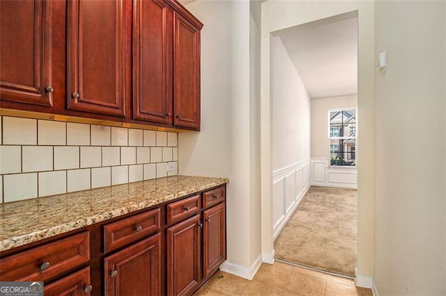 kitchen with light carpet, tasteful backsplash, and light stone countertops