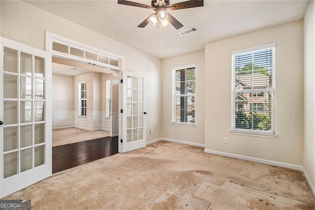 empty room with ceiling fan, light hardwood / wood-style floors, and french doors